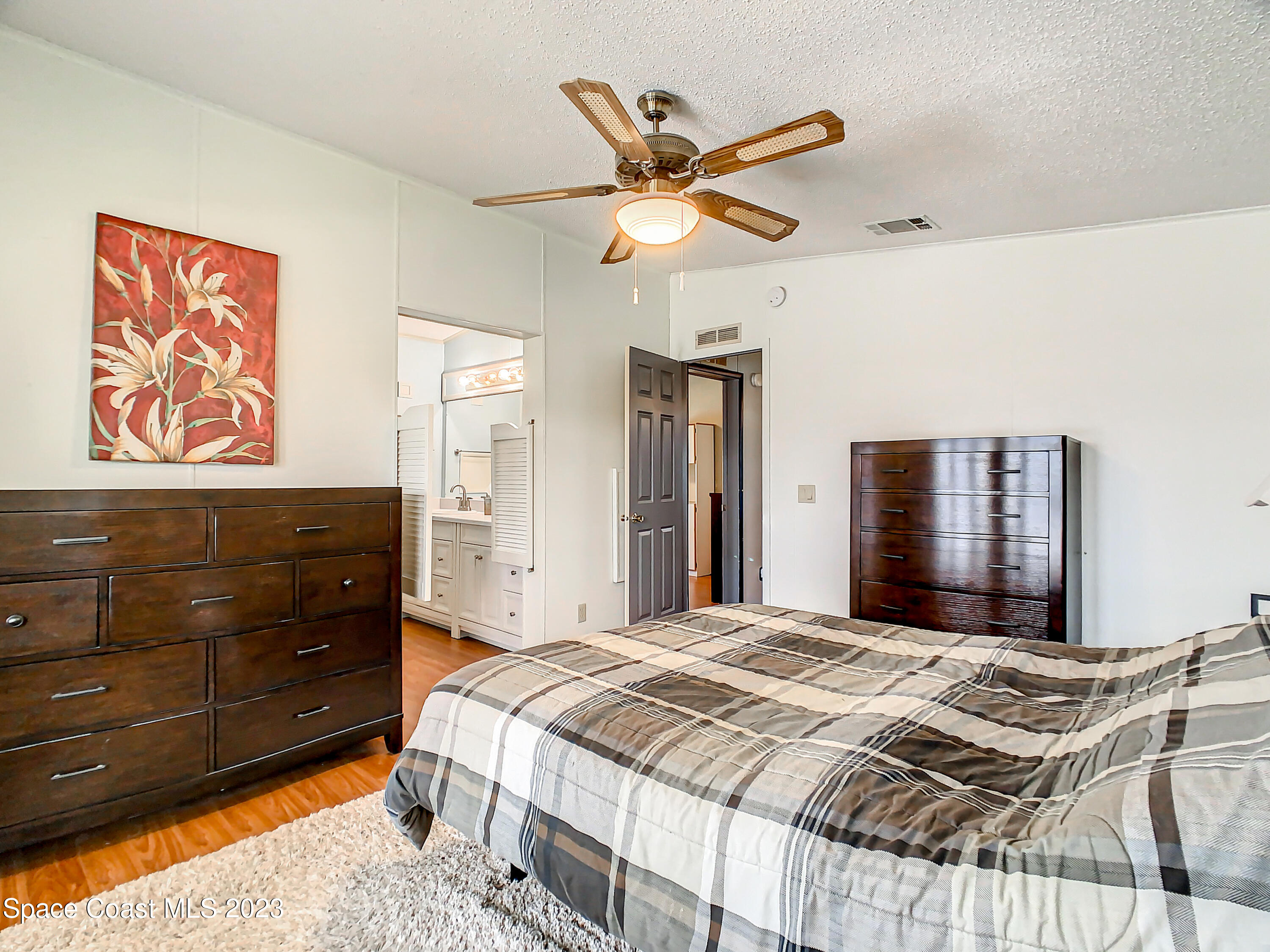 832 Periwinkle Circle Sebastian, FL 32976 - Photo 27 of 52 a bedroom with a bed and a chandelier