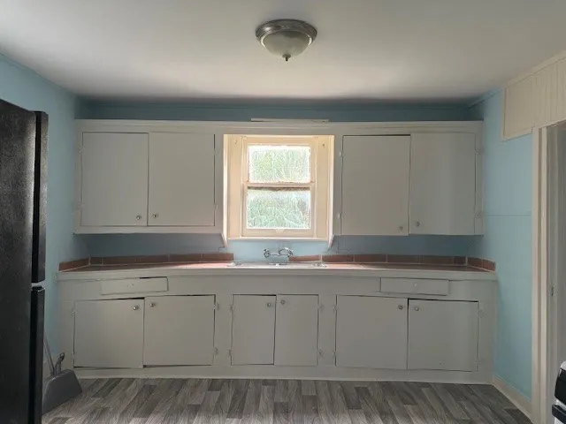 a kitchen with white cabinets and sink