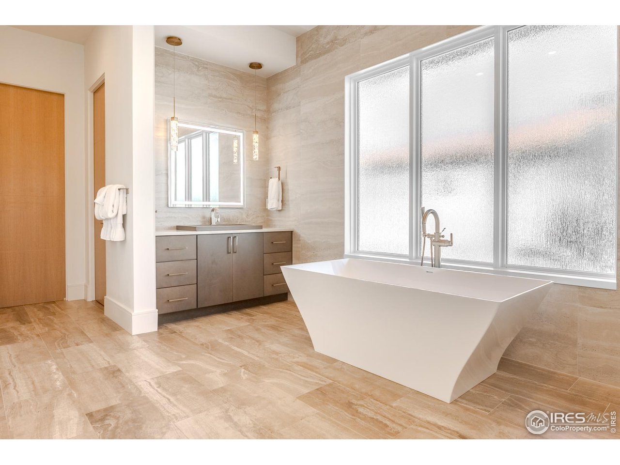 7572 Raphael Lane Littleton, CO 80125 - Photo 21 of 50 A broad opaque window invites daylight to fill the bath in a calm, luminous wash.
