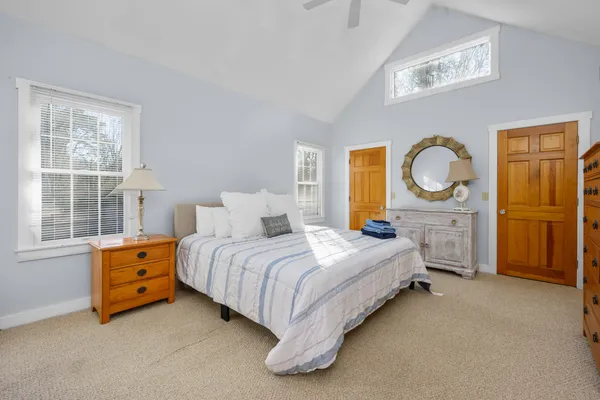 a bedroom with a bed and a dresser next to a window