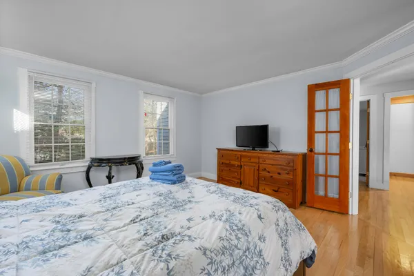a bedroom with a bed and wooden floor