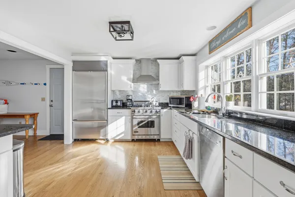 a kitchen with stainless steel appliances a stove top oven a sink a refrigerator and cabinets
