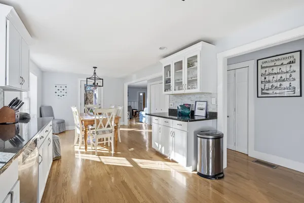 a living room with stainless steel appliances granite countertop a dining table chairs and view of living room