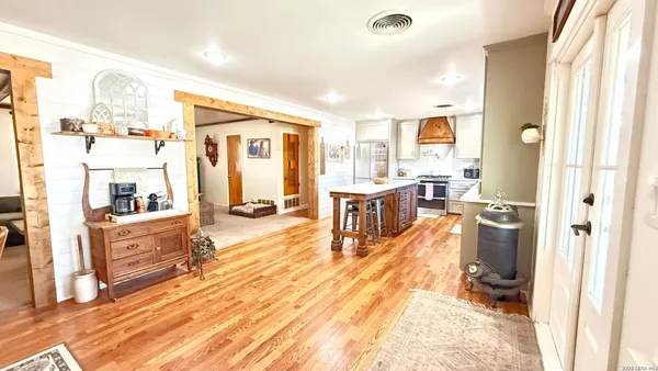 a living room with stainless steel appliances furniture and a kitchen view
