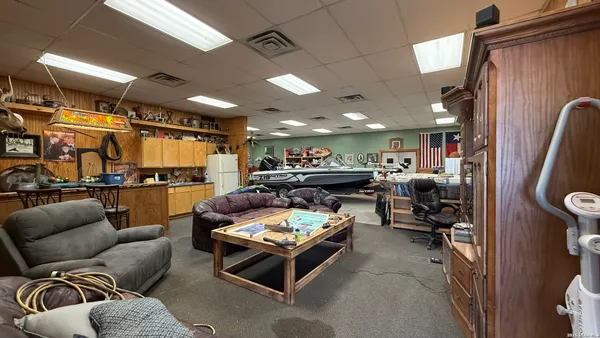 a living room with furniture kitchen view and a chandelier