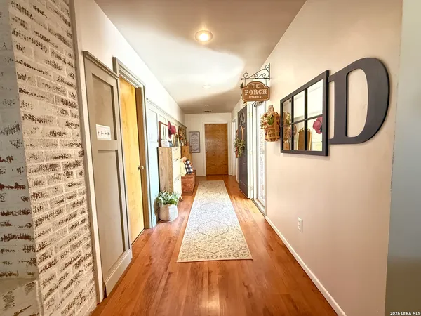 a view of a hallway with wooden floor and staircase