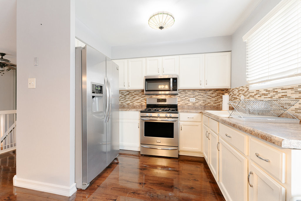 241 Huntingwood Road Matteson, IL 60443 - Photo 9 of 18 a kitchen with granite countertop white cabinets and stainless steel appliances