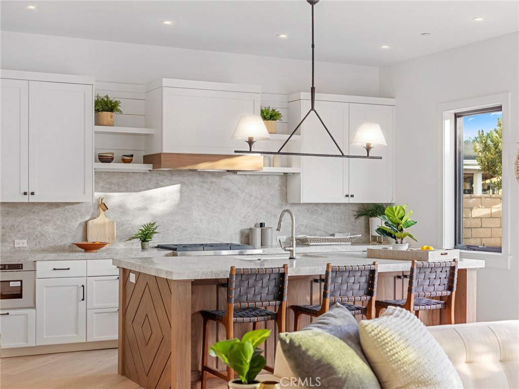 379 La Perle Place Costa Mesa, CA 92627 - Photo 2 of 8 a kitchen with stainless steel appliances granite countertop a stove a sink and a refrigerator