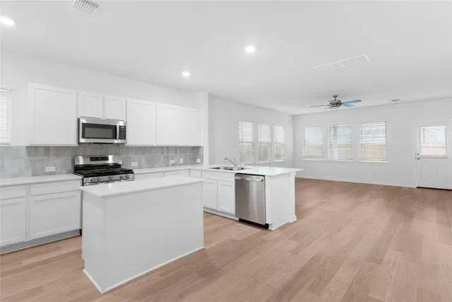 a kitchen with granite countertop white cabinets and white appliances
