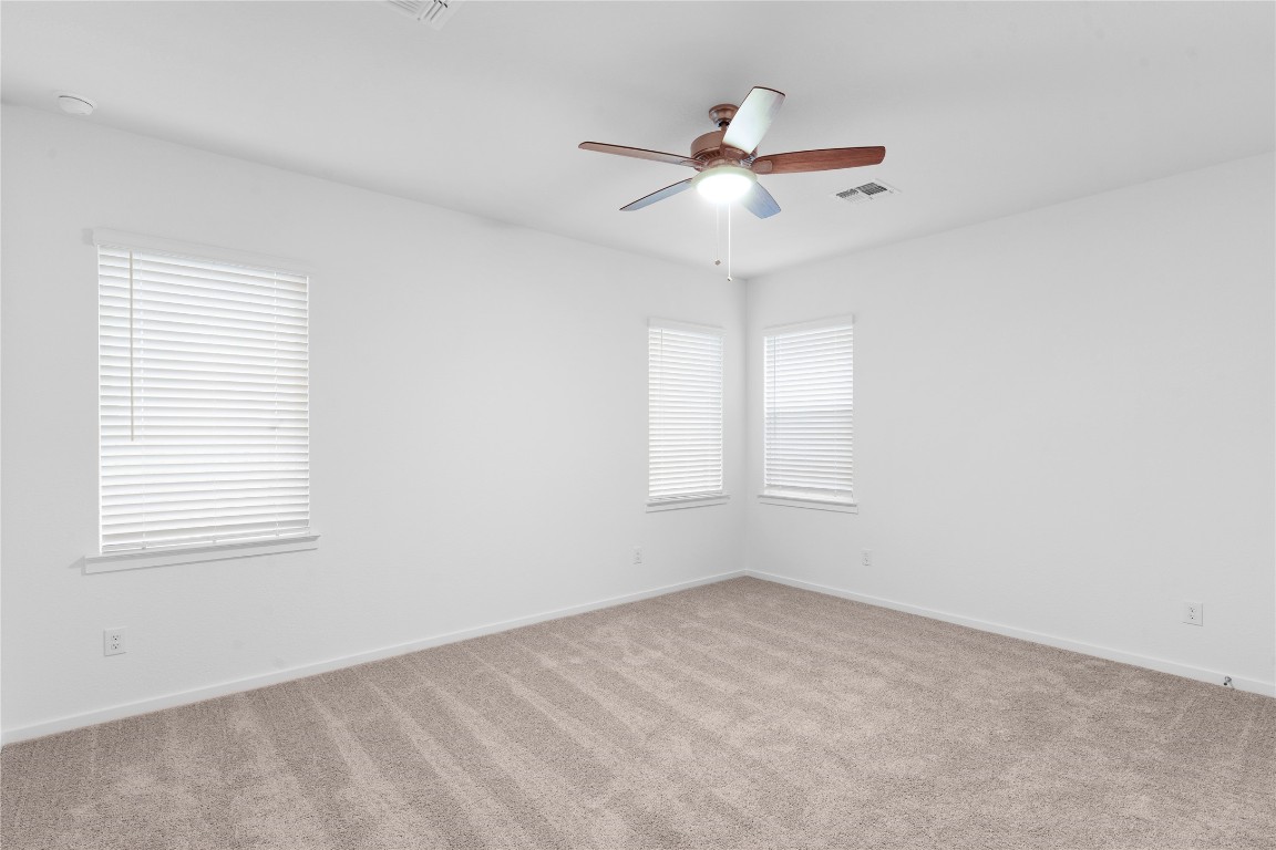13725 Tucker Hedge Pass Elgin, TX 78621 - Photo 14 of 29 an empty room with a window and ceiling fan
