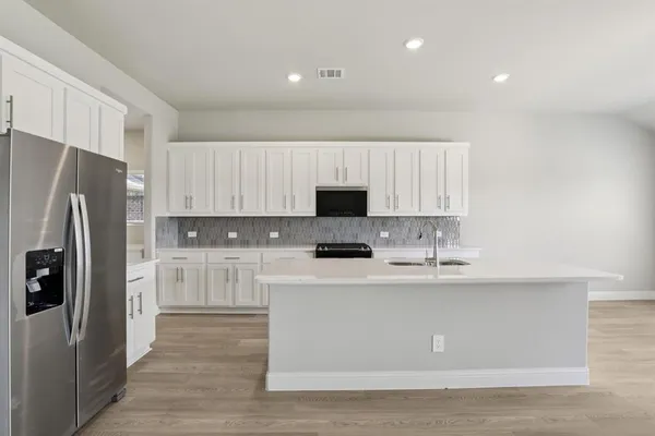 a kitchen with stainless steel appliances a refrigerator and a stove top oven