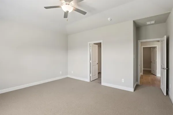 an empty room with a ceiling fan and a window