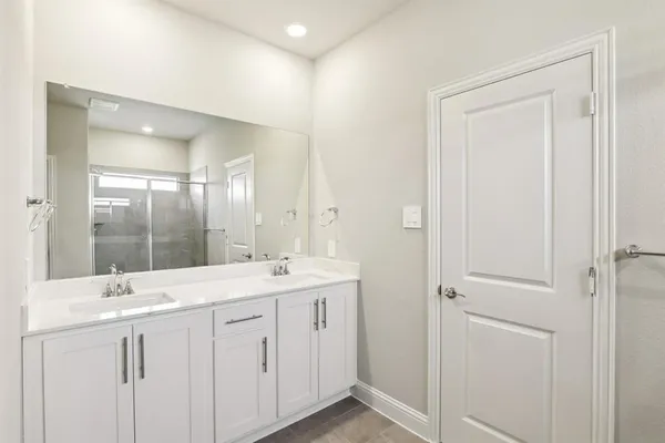 a bathroom with a double vanity sink and mirror with shower