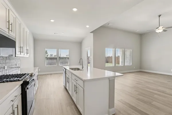 a kitchen with stainless steel appliances granite countertop a sink stove and wooden floor