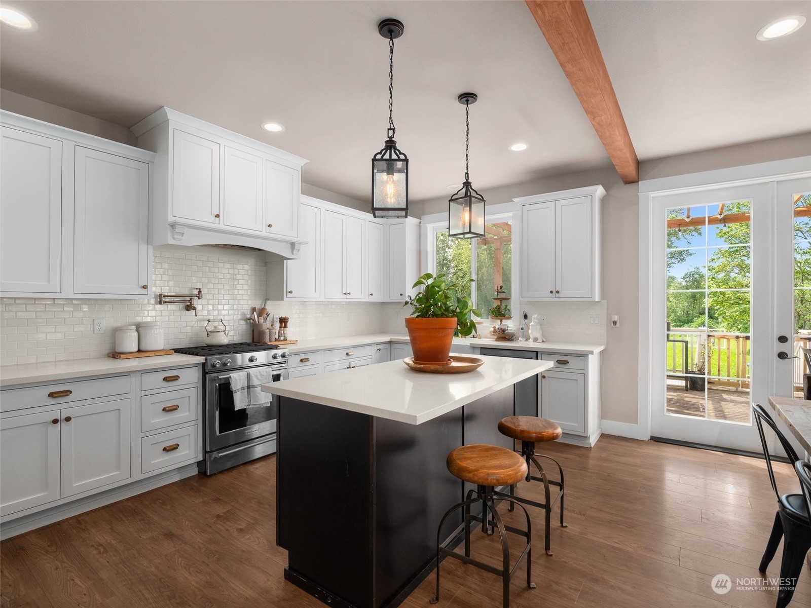 2440 Callow Road Lake Stevens, WA 98258 - Photo 4 of 34 a kitchen with stainless steel appliances kitchen island granite countertop a stove a sink a dining table and chairs with wooden floor
