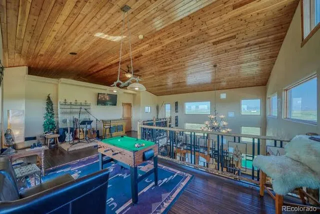 a view of a balcony with chairs and wooden floor