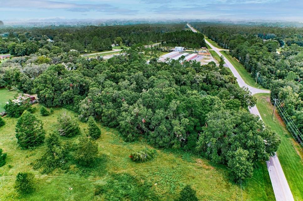 an aerial view of residential houses with outdoor space and trees