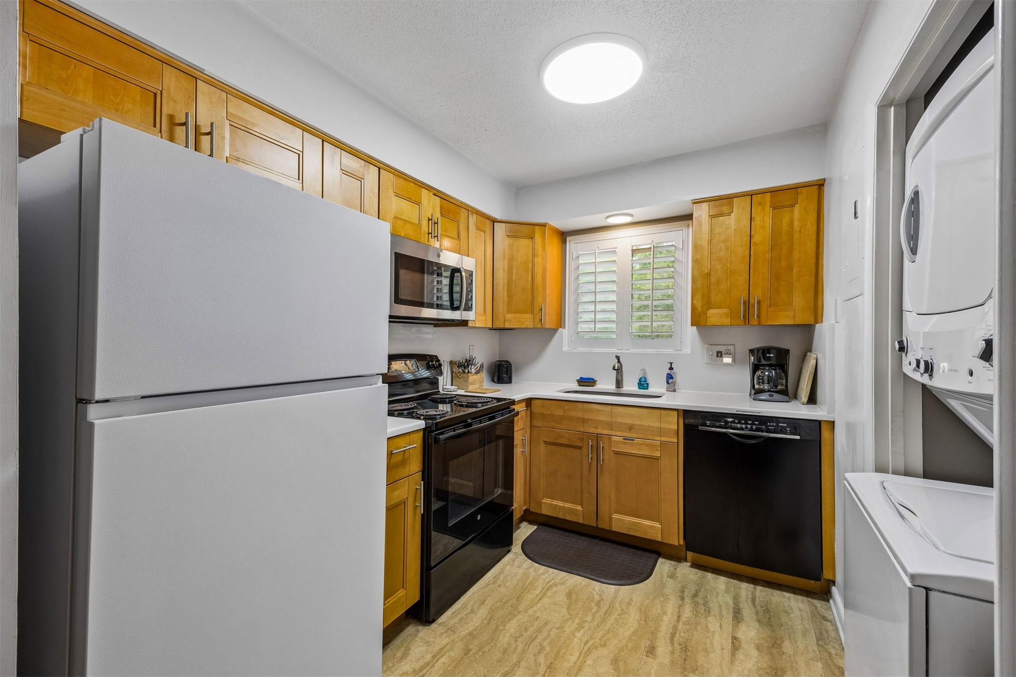 2328 Sadler Road, Unit 1C Fernandina Beach, FL 32034 - Photo 12 of 49 a kitchen with a refrigerator a stove a sink dishwasher and wooden cabinets