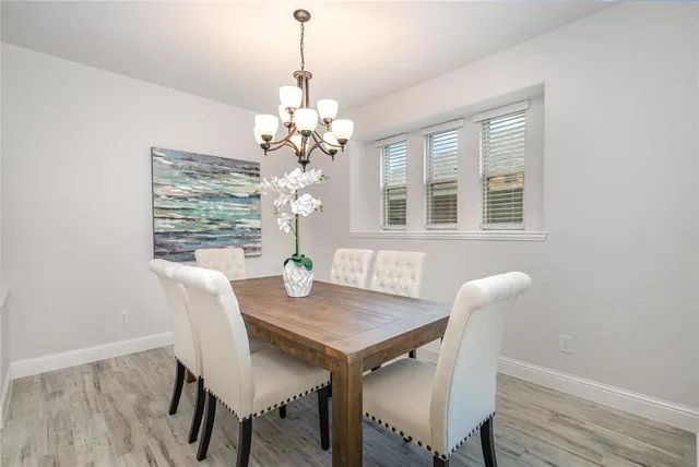 a view of a dining room with furniture a chandelier and wooden floor