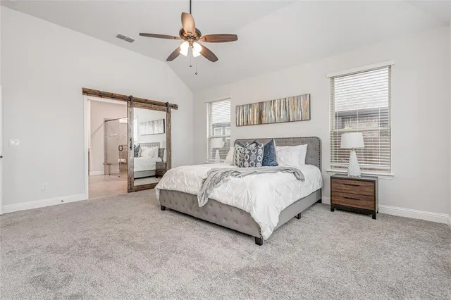 a spacious bedroom with a bed and a chandelier