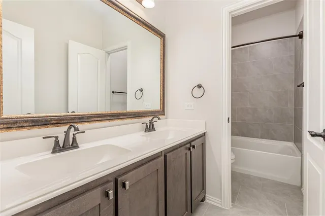 a bathroom with a sink and a mirror with bathtub