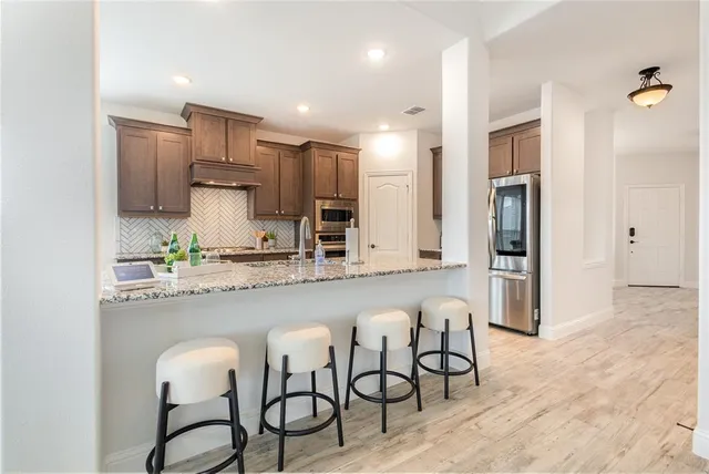 a kitchen with stainless steel appliances a sink and a refrigerator