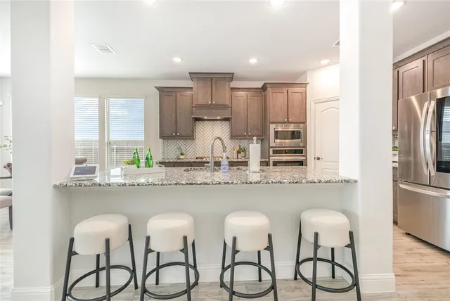 a kitchen with stainless steel appliances granite countertop white cabinets and a granite counter tops