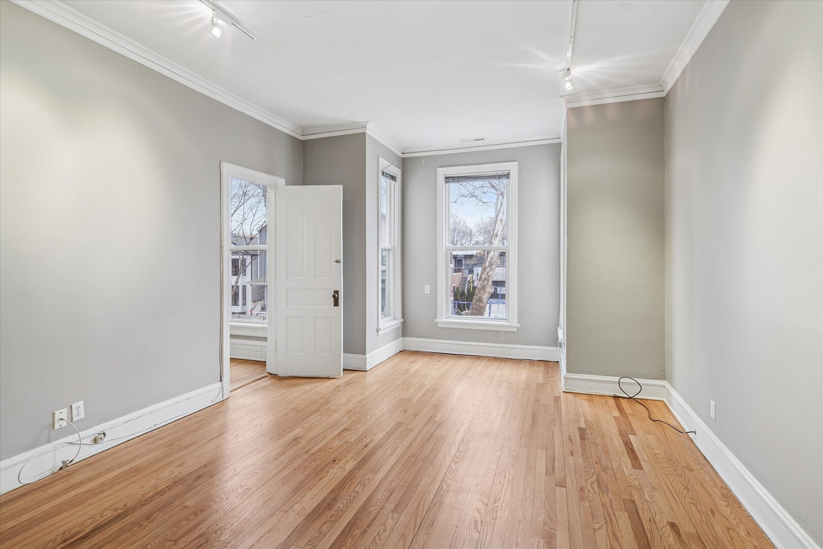 3818 North Hermitage Avenue, Unit 2 Chicago, IL 60613 - Photo 2 of 16 an empty room with wooden floor and windows
