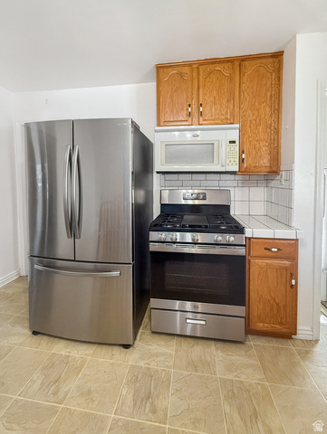 Kitchen area featuring stainless steel appliances, including a French door refrigerator and a gas range