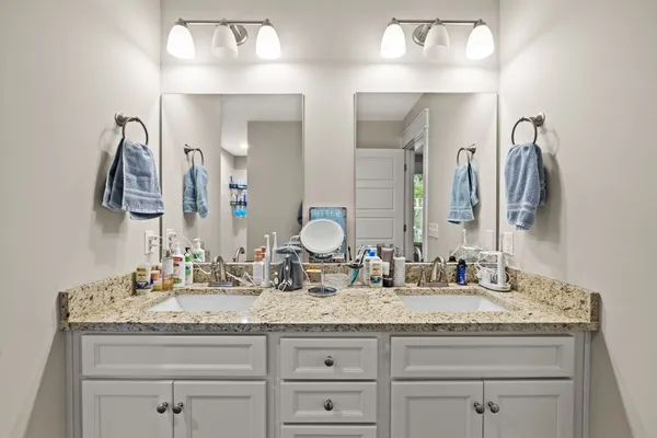 a bathroom with double vanity and a mirror