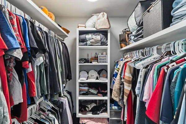 a view of walk in closet with clothes and shoes