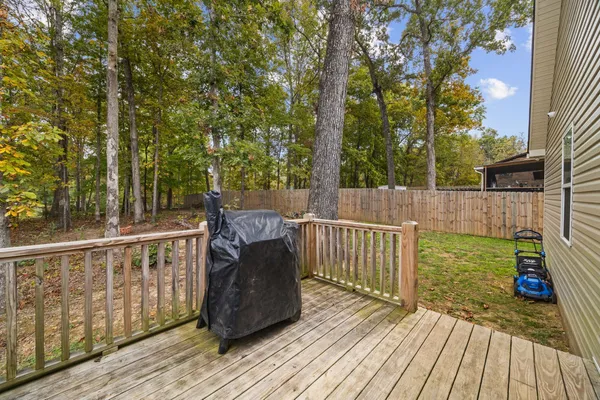 a view of deck with furniture and trees in the background