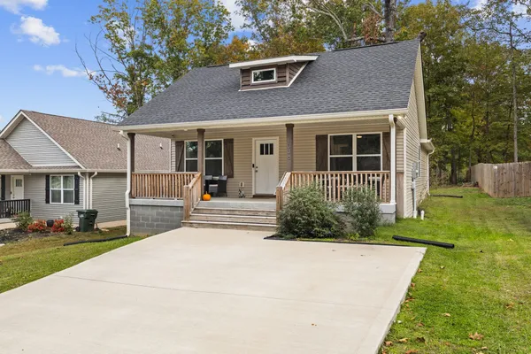 a view of a house with a yard and sitting area