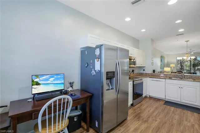 a kitchen with sink refrigerator dining table and chairs