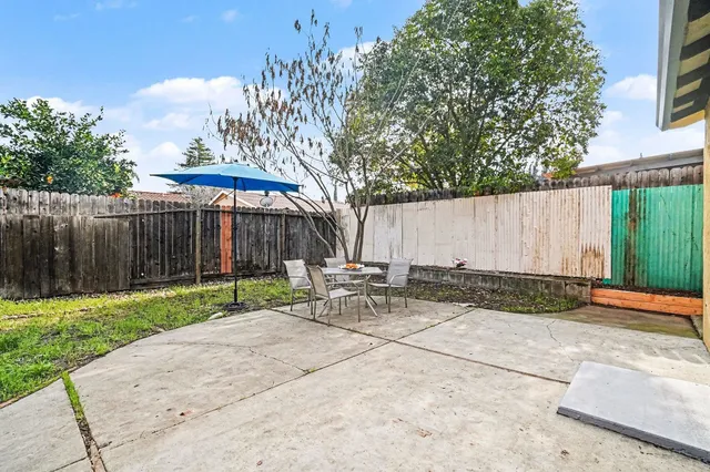 a view of a patio with table and chairs with wooden fence