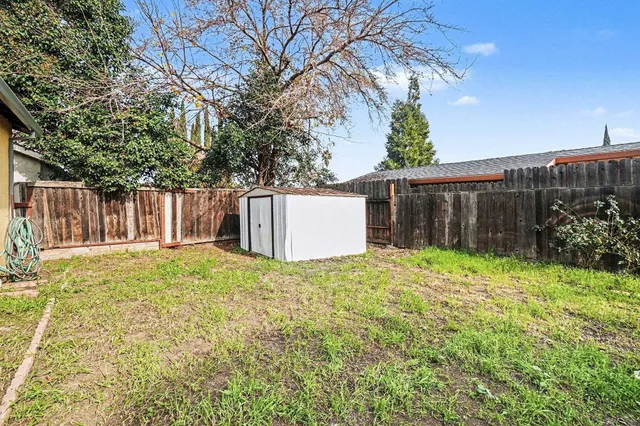 a backyard of a house with a barn and a large tree