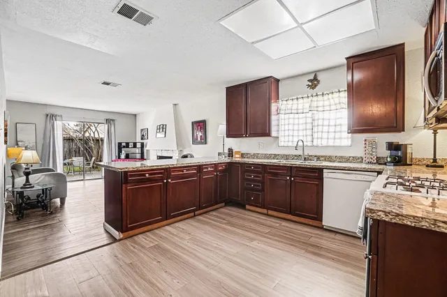 a kitchen with stainless steel appliances granite countertop a sink stove and refrigerator