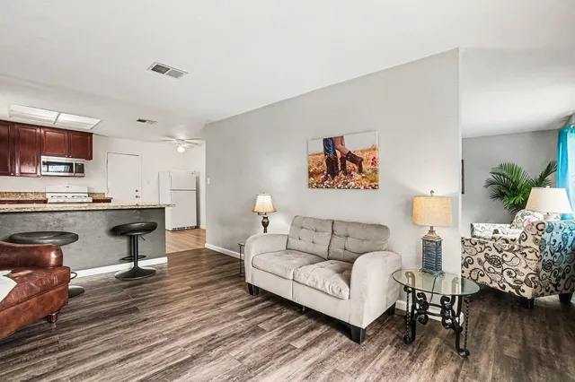a living room with furniture and a wooden floor