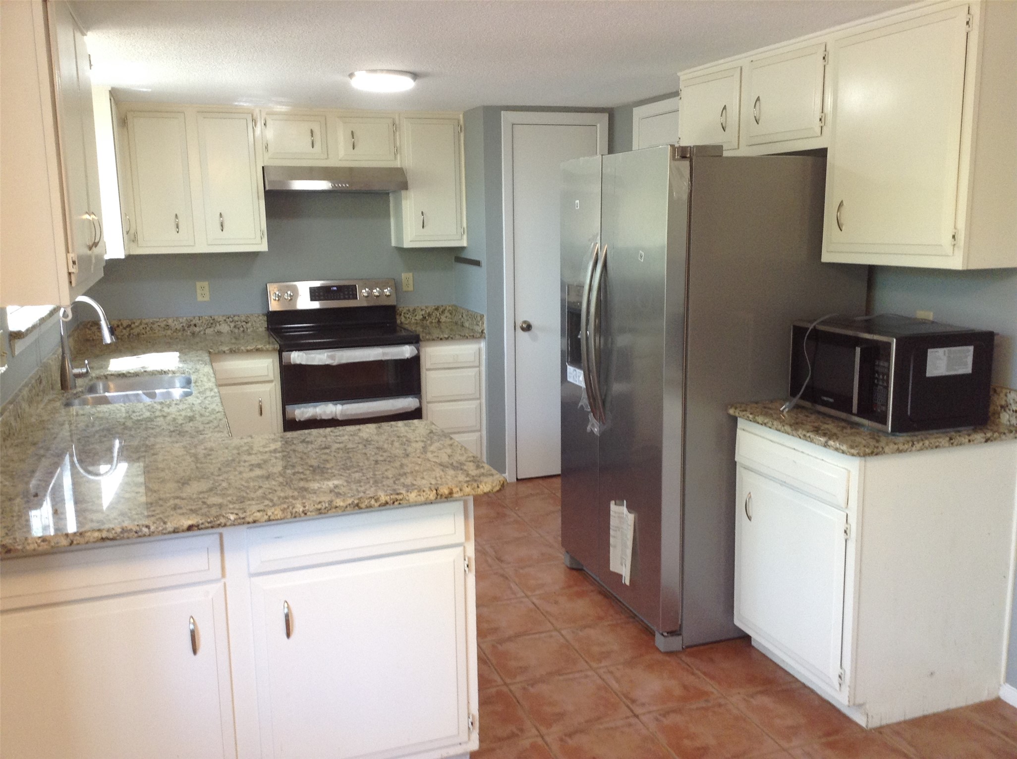 12007 Scribe Drive Austin, TX 78759 - Photo 6 of 35 a kitchen with kitchen island granite countertop stainless steel appliances and refrigerator