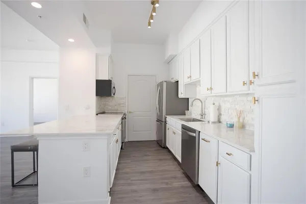 a kitchen with white cabinets and white appliances