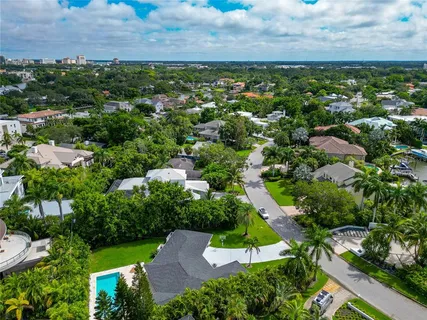 an aerial view of residential houses with outdoor space and trees
