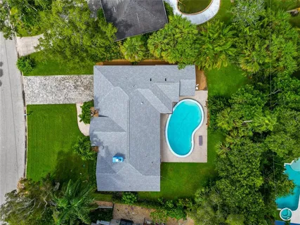 an aerial view of a house with a swimming pool and outdoor space