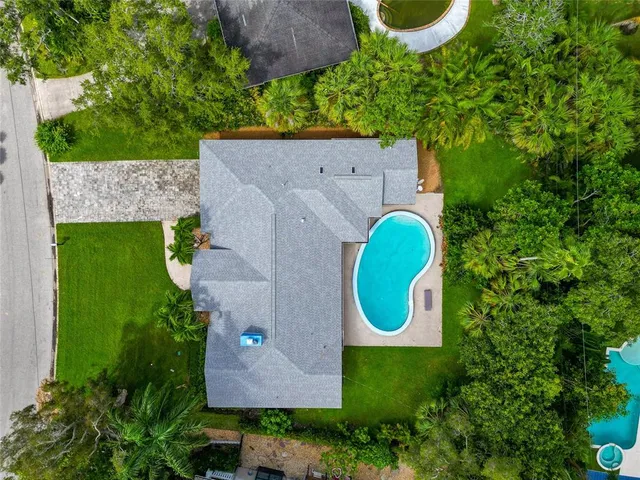 an aerial view of a house with a swimming pool and outdoor space