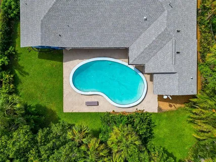 an aerial view of a house with swimming pool and garden