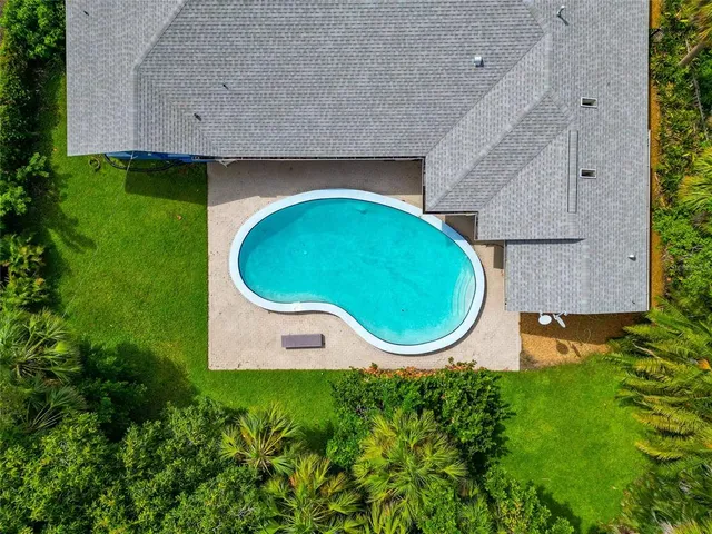 an aerial view of a house with swimming pool and garden