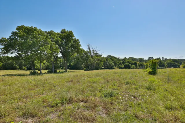 a view of open field with trees in the background