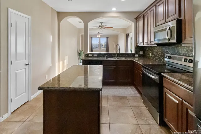 a kitchen with stainless steel appliances granite countertop a sink and a stove