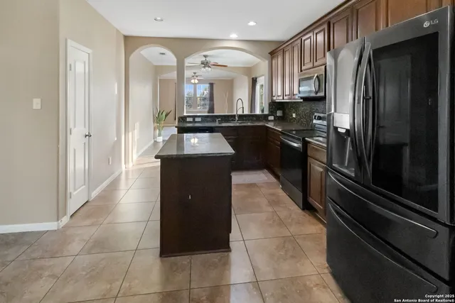 a kitchen with stainless steel appliances granite countertop a refrigerator and a sink