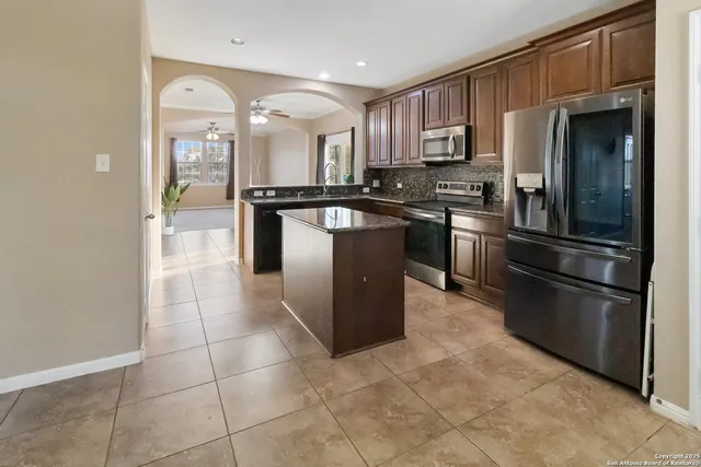 a kitchen with stainless steel appliances granite countertop a refrigerator and a sink