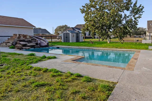 a front view of a house with garden and a car